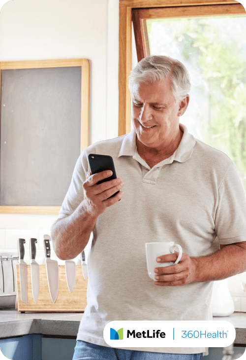 Old man in a kitchen looking at his phone
