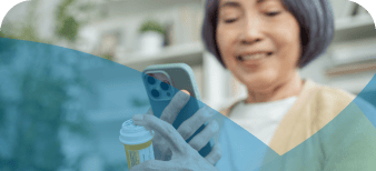 Older woman on phone and staring at a bottle of medication