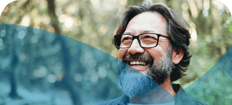 Middle aged man in glasses smiling outside