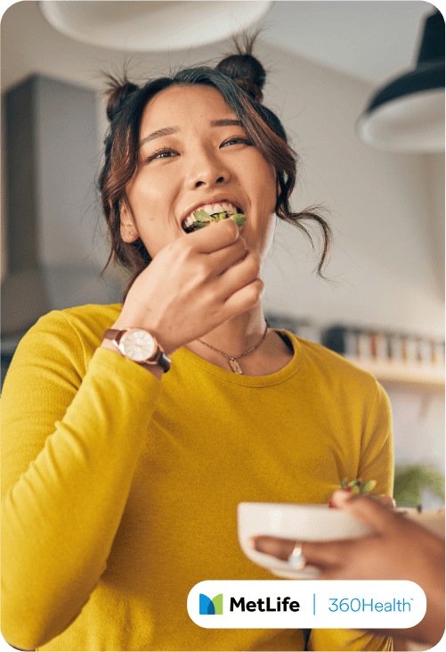Young woman in yellow sweater eating food