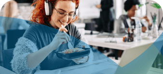 Young woman eating lunch at her desk in an office