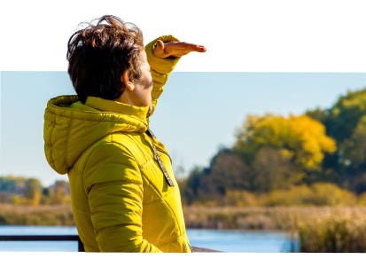 Women in yellow jacket staring far away with her hand blocking the sun