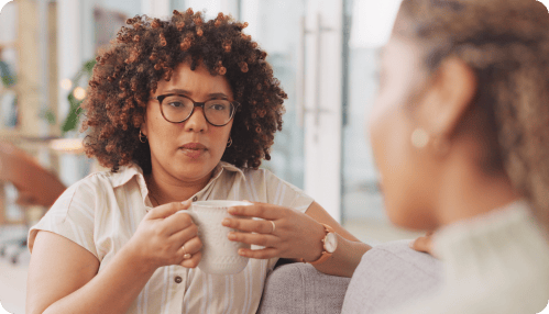 Man smiling at his female partner leaning over his shoulder.