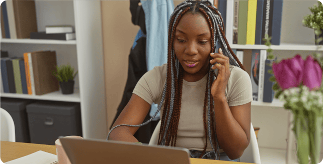 Woman speaking on phone while on her laptop